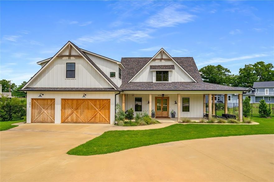 Just one hour from Dallas, 205 Oak Creek Drive isn’t just a lake house—it’s a destination. Perched above the shoreline in the heart of Cedar Creek Lake, this custom modern farmhouse delivers sweeping water views, refined indoor-outdoor living, and spacious design ideal for gathering friends and family year-round. Inside, the open-concept layout centers around a vaulted great room with warm wood beams, shiplap walls, and a stone fireplace. Expansive windows and French doors flood the space with natural light and stunning lake views. The designer kitchen boasts quartz countertops, a large island, and premium finishes—perfect for morning coffee, holiday spreads, or casual dinners for twelve. The flexible layout includes a main-floor study (or guest suite) with a full bath, plus a secluded primary suite with private patio access to enjoy sunrise on the water. Upstairs, two guest bedrooms with en-suite baths provide comfort and privacy, while the massive rec wing includes a bunk nook, full bath, game room, and private bedroom—ideal for kids, teens, or extended guests. Outside, a wraparound covered porch with porch swings, an outdoor fireplace, and built-in grill offers the ultimate entertaining space—perfect for hosting Thanksgiving by the fire or watching football with a lake breeze. The fenced yard leads to a private boathouse with a 25-ft boat slip, two jet ski lifts, and a party deck with open water views. Located in the friendly Arnold Hills community, 205 Oak Creek is perfect as a full-time home, holiday hub, or weekend retreat—just a short drive from the city, but a world away in experience.