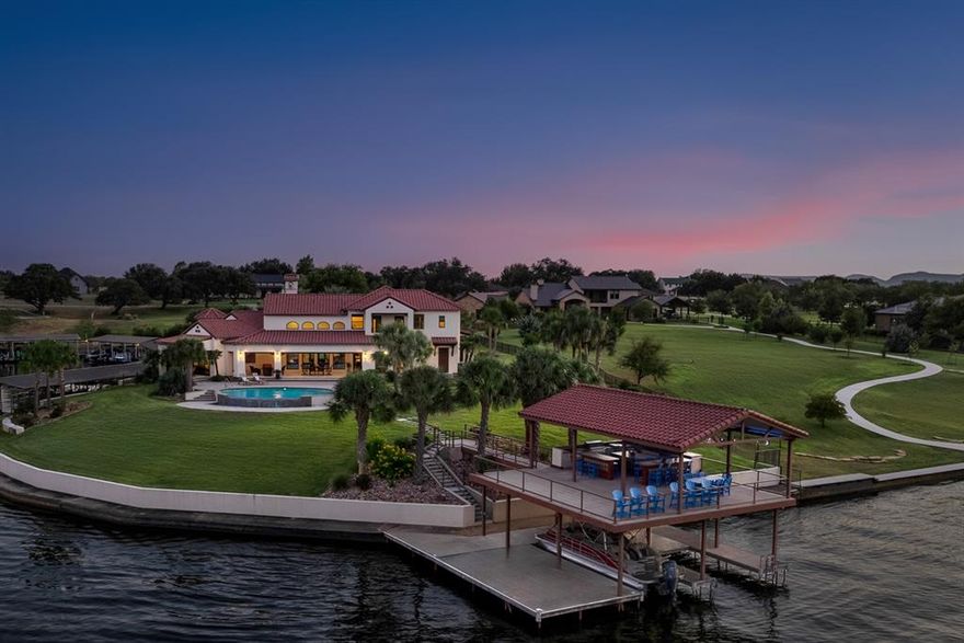 Stunning 3-acre waterfront estate in the prestigious Legends on Lake LBJ community with over 300 feet of Colorado River frontage. This fully furnished and meticulously maintained custom-built 4 bed 4.5 bath home offers luxury living inside and out. Features include a gourmet kitchen with commercial-grade appliances, imported tile accents, and spacious bedrooms each with their own en-suite bathroom. The primary suite boasts a spa-like bath, coffee bar, and private patio with lake views. Outdoor living is unmatched with a resort-style infinity pool, expansive covered patio, and a two-story boat house complete with two boat slips with hydraulic lifts, two jet ski slips, and a full outdoor kitchen. Located on constant-level Lake LBJ in the highly sought-after gated golf community The Legends, just minutes from Kingsland and a short drive to Austin or San Antonio. Perfect for full-time living or a turnkey lake retreat.