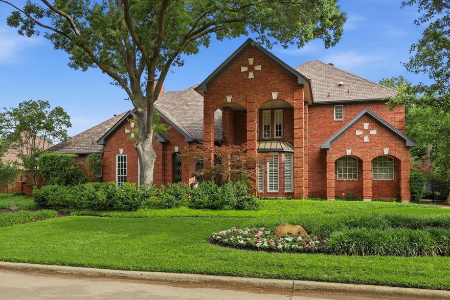 Nestled among mature trees in an established North Dallas neighborhood, this elegant residence offers a rare blend of timeless design, generous space, and a resort-style outdoor setting—all within Plano ISD and moments from the Dallas North Tollway and President George Bush Turnpike.
From the moment you enter, soaring ceilings and immediate sightlines to the backyard oasis create a striking first impression. Walls of glass frame the sparkling pool and multiple outdoor living areas, creating a seamless indoor-outdoor lifestyle ideal for both entertaining and everyday living.
Thoughtfully designed, the home features four spacious bedrooms, each with its own private ensuite bath. The primary suite is conveniently located on the main level and offers a tranquil retreat with a sitting area and cozy fireplace, while a private guest suite downstairs provides ideal accommodations.
Multiple living and dining areas enhance the home’s flexibility, including a formal living room with fireplace and a spacious family room with a wet bar. A dedicated downstairs office showcases custom built-ins, a vaulted ceiling, and plantation shutters, creating an inspiring and private workspace. The large, beautifully appointed kitchen serves as the heart of the home, featuring a built-in refrigerator, double ovens, walk-in pantry, and generous prep space. Perfectly positioned between two dining areas, it also offers direct access to a side patio for effortless entertaining. Upstairs, dual staircases lead to additional living spaces ideal for a game room, library, or additional office, along with two bedrooms and a laundry chute. Outdoors, the private pool and multiple seating areas create a serene backyard oasis surrounded by lush landscaping. A three-car garage adds convenience and ample storage. Ideally located a short distance to shopping and dining, this home offers an exceptional combination of privacy, accessibility, and elevated North Dallas living.