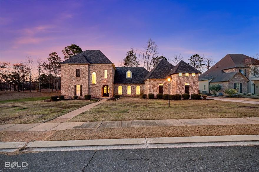 Experience refined living in this custom-built, one-owner home located in a sought-after golf course community in Bossier Parish. Offering 5 bedrooms, 3.5 bathrooms, a pre-wired media room, and an unfinished bonus space above the garage, this property provides flexible living options to suit a variety of needs. Situated along the 8th green of Olde Oaks Golf Course, the home enjoys a wooded backyard view and a peaceful setting. The kitchen is designed for both everyday living and entertaining, featuring a commercial-grade 36-inch 5-burner gas range, pot filler, spacious island with bar sink, granite countertops, custom cabinetry, stained concrete flooring, and a new dishwasher. The living area includes a wood-burning fireplace with gas assist and flows seamlessly into the dining space. The first floor offers a private primary suite with tray ceiling and ensuite bath, along with an additional bedroom and full bath. A convenient half bath is located just off the main living area. The laundry room includes a utility sink and ample natural light. Upstairs you will find three additional bedrooms, a full bathroom, a pre-wired media room, and a large unfinished space that can be customized for a game room, office, fitness area, or additional storage. Additional features include a two-car garage with extended storage space suitable for tools or recreational equipment, a new roof (2024), new tankless water heater (2025), three high-efficiency 2-stage HVAC systems with smartphone controls and a whole yard irrigation system. The covered back patio includes an outdoor fireplace and is plumbed for a future outdoor kitchen. Convenient to Barksdale Air Force Base, hospitals, shopping and restaurants! This property offers a combination of space, functionality, and golf course views in a well-established community setting. Call me or your favorite real estate professional today to schedule your private tour!