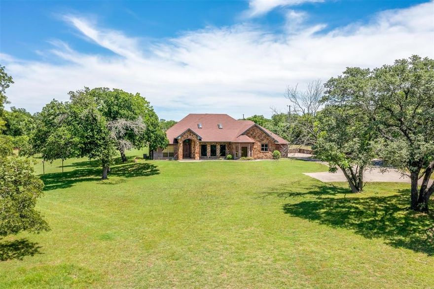 Discover your dream retreat in the heart of Aledo, Texas. This stunning, custom-built, ranch-style home is nestled on nearly 3 acres of serene, treed land. Perfect for families, pets, and horses. Enjoy the freedom of no HOA, no city taxes, and unparalleled privacy in a highly sought-after location offering the best of country living with city conveniences just minutes away. A single-level masterpiece, this home boasts thoughtful design and modern comforts, including Spacious Interiors, Rich wood molding, new neutral carpet, tile flooring, and abundant natural light from multiple skylights. The thoughtful layout features a formal dining room, an expansive living room with a stone fireplace & built-ins, a dedicated study, a large laundry room, and a Private Primary Suite with a sitting area, access to the covered back patio, and a second living room. The Gourmet Kitchen includes Custom island, GE Monogram stainless gas cooktop with griddle, double ovens, Bosch elevated dishwasher, butler’s pantry, and ample counter space. Unwind on the front porch and savor breathtaking Texas sunsets, overlooking a pond framed by majestic oaks, or enjoy a morning coffee watching the wildlife and sunrises from the secluded back porch. The Oversized 2-car garage features additional storage with shelving and an In-Ground Storm Shelter for easy access without getting wet outside! With ample storage options including a lean-to and storage shed, you can bring your boats, trailers, & RVs, or add additional shops and garages without HOA or city permitting hassles!! No need for off-site storage! Just 30 minutes from Downtown Fort Worth, the Stockyards, Cultural District, Bass Hall, and Dickies Arena, this home blends rural charm with easy access to urban entertainment. And don't forget the award-winning Aledo School District!
