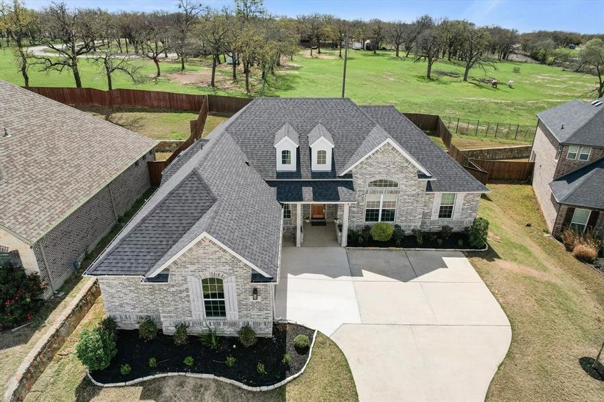 This beautiful Windmiller home offers comfort, functionality, and peaceful surroundings—backing to a ranch where Longhorn cattle graze, creating a truly unique and private backdrop. Inside, rich luxury vinyl plank floors welcome you and set the tone for the open, inviting layout. A wall of windows along the back fills the home with natural light and showcases serene backyard views. The spacious family room with soaring ceilings and a stunning gas fireplace with stacked stone—offers a cozy focal point and entertainer’s dream—flowing seamlessly into the kitchen. Designed with both luxury and practicality in mind, the kitchen boasts white cabinetry, quartz countertops, GE Profile appliances, and useful storage throughout. The Whirlpool side-by-side refrigerator can remain.  Filtered drinking water at the sink and expanded pantry space add everyday convenience. With a split-bedroom floorplan for privacy, the primary suite is tucked off the kitchen. Here the warm hardwood flooring continues. Electronic shades enhance the natural light and capture peaceful backyard views. The ensuite bath features a Jetta Advantage soaking tub, separate shower with bench, dual vanities, and a generous walk-in closet. A large study with French doors and closet provides the perfect space for a home office, guest room, or flex space. Secondary bedrooms are spacious, with one offering direct access to the hall bath via a pocket door—ideal for guests or multi-generational living. The laundry room is equipped with additional cabinetry and a folding area, and the GE Profile washer and dryer can remain with the home. Step outside to a backyard retreat that’s hard to find in a subdivision—private, peaceful, and designed for relaxation with a covered patio and pull-down sunscreens. Additional features include a 20’ x 25’ garage and an ONIT home filtration system. Conveniently located near Hidden Creek Golf Course, retail, restaurants, Russell Farm Art Center, HEB. Ask for full list of updates.