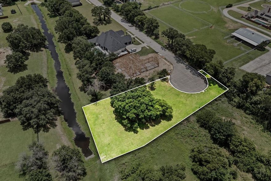 Discover the perfect canvas for your custom dream home at 7601 Awadi Court, nestled in the exclusive Lazy River community—one of Arlington’s best-kept secrets. Surrounded by luxury estates and zoned for the award-winning Mansfield ISD, this serene cul-de-sac lot offers a rare opportunity to build in a neighborhood that blends elegance and privacy. Lazy River is a hidden gem with just 14 homesites, each positioned to enjoy water views. Set among mature trees and adjacent to privately owned acreage, this premium, treed lot offers both natural beauty and added privacy. The perfect spot to design the outdoor living area you’ve always imagined—whether it's a pool, garden, or spacious patio. Its central location between Dallas and Fort Worth means you can enjoy a relaxed lifestyle without sacrificing proximity to the city. Bring your builder and explore the possibilities this unique lot has to offer.