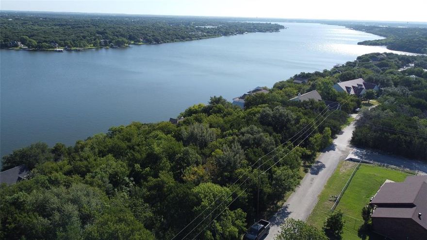 Unmatched Lake Views & Build-Ready Lot in Gated Canyon Creek! Prepare to be captivated by breathtaking panoramic views of Lake Granbury, framed by majestic hardwood Live Oak trees that offer both beauty and shade. This rare offering includes two spacious lots sold together, providing an abundance of room to build your custom dream home with privacy and flexibility. Perched high on a bluff, this property delivers a true “wow” factor—offering unobstructed, elevated lake vistas that stretch for miles. The property line extends all the way to Rock Ridge Drive, guaranteeing that your views will remain protected and unspoiled for years to come. location on a quiet street in gated Canyon Creek subdivision. The impressive neighborhood amenities include 2 boat ramps, fishing pier, baseball park, basketball courts, clubhouse, park & picnic areas, kids playgrounds, RV park spaces, sandy beach area, 2 swimming pools, Tennis Courts, and 24 hour on-site security. With gentle topography for easy construction, these lots offer the perfect canvas for your lakeview retreat. Whether you’re ready to build now or invest in your future, don’t miss the chance to own a slice of paradise with million-dollar views at a fraction of the cost.