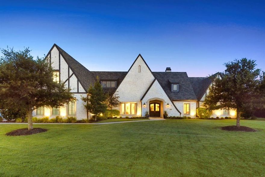 Positioned within the exclusive gated community of Christie Farms in Prosper, this one-of-a-kind European Tudor-style masterpiece by Crest Custom Homes offers an extraordinary opportunity. This timeless residence is unmatched in character and craftsmanship, showcasing German smear brick, copper gutters, and diagonal lead glass windows. A dramatic wainscoted entry opens to 5in white oak floors laid in herringbone, guiding you into the expansive great room. The open-concept design blends the living room, dining, wet bar, and chef’s kitchen. The space is anchored by a grand cast stone fireplace flanked by soaring built-ins. The gourmet kitchen is a showpiece, featuring top-tier Thermador appliances, including a 48in gas range with dbl ovens, paneled 48in fridge-freezer, drawer microwave, and dishwasher. A marble-wrapped island is complemented by soapstone perimeter counters that are both beautiful and functional. Designed for comfort and luxury, the primary suite is a serene retreat with gas fp, sitting area, spa-inspired marble ensuite, and a large custom walk-in closet with island. Enjoy the office for work at home, or use this room as a formal dining, living, or a 6th bedroom. Versatility continues with two additional living areas. A media or game room off the main living space offers entertainment or use as an in-law suite. A second media room upstairs adjoins the fifth bedroom. Indoor-outdoor living is achieved through 8ft custom sliding glass doors opening to over 750sf of covered outdoor space. Here, you'll find a Claffey-designed pool, full outdoor kitchen and bar, dining area, lounge with fireplace, and ample room for entertaining year-round. The sprawling backyard is landscaped with over 40 strategically placed trees offering privacy with space for a sports court, pool house, workshop, and additional garages. Additional features include a 3-car garage, 6 full baths, and full home Generac generator. Prosper ISD & Walnut Grove HS!