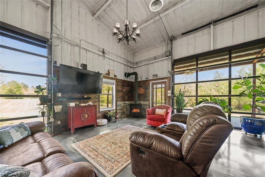 This one-of-a-kind industrial-style barndominium, built in 2020, sits on nearly 14 acres of beautiful rolling East Texas land just minutes from Tyler and Athens—and best of all, it has no restrictions. With a modern design and custom features throughout, this unique home offers a rare opportunity for stylish and versatile country living.
Inside, youll find 3 bedrooms plus a flexible 4th room that can serve as a bedroom, office, or game room, complete with a closet and access to floored attic storage. The primary suite includes a walk-in closet and a private bath with a zero-entry walk-in shower. Two guest rooms feature built-in beds, dressers, and loft spaces, and share a full bath. A separate utility room houses the electrical panel, tankless water heater, and whole-home water filtration system.
The open-concept living area includes two 10x10 garage doors that open to a covered patio with thermal power screens—perfect for indoor-outdoor entertaining. The kitchen features KitchenAid appliances, a large island with USB and power outlets, a farmhouse sink, pass-through window, and a walk-in pantry with a peek-a-boo cutout for a robotic vacuum.
Other highlights include a detached studio with HVAC, fiber internet, and electricity; a large storage shed with power; two additional sheds; a chicken coop; second washer dryer hookup; and a 200-amp RV setup with 5030-amp power, sewer, and water. A concrete pad is ready for expansion, and a private 110-yard tee box with green adds a fun touch. With 2.5 garage spaces, a carport, and fiber internet, this property is the perfect blend of comfort and freedom.