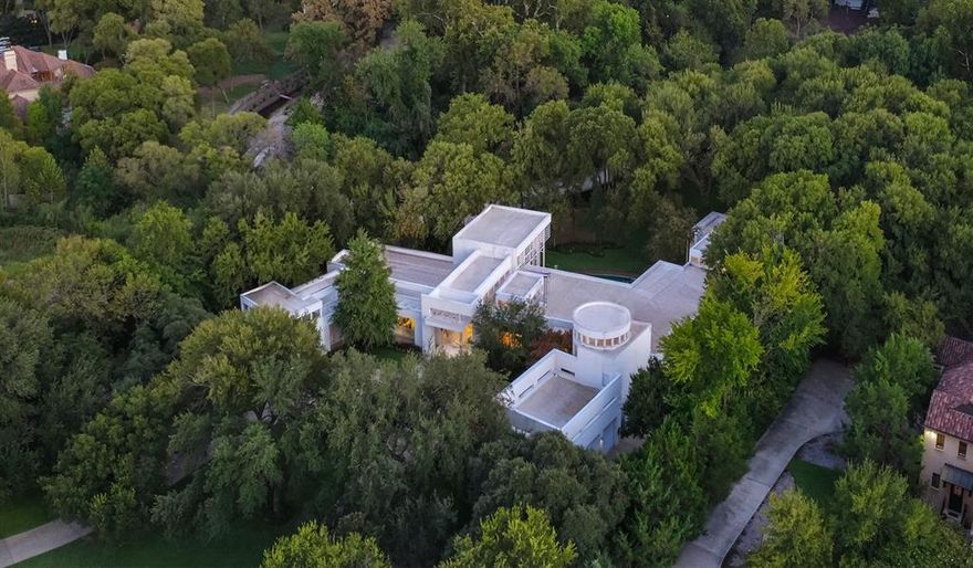 A stunning setting on rare 3.38 acres in the coveted Bluffview area of Dallas, featuring hard to find ONE STORY footprint, giving enormous scale and lifestyle to every room. This approx 9,000 sqft iconic estate has been the host for several movies and TV series, national commercials and publications, the gathering spot for many large community events, in addition to their everyday fun family living. Spectacular in everyway, the front gives off the quiet, private approach that was key to the location selection, while the interior and backyard's striking modern design w 6,000 sq ft of glass, 71,000 lbs of steel giving the most gorgeous unobstructed views of the spectacular nature and indoor-outdoor lifestyle surrounded by the tranquil creek setting. Renowned architect Guy Courtney skillfully designed patterns of Richard Meirer's work on the Getty Museum in LA in this estate, allowing the perfect backdrop for the seller's extensive art collection, large scale entertaining needs and resort relaxation atmosphere that takes in all the beauty year round. Wanting to be connected to the natural surroundings at every turn, the primary bath is a perfect example of pampering in the tree house like experience while enjoying all today's comfort amenities. The sellers took in their service staff input to design the gourmet kitchen w 3 ovens, 3 sinks and a silver cloth lined pantry for optimal entertaining needs. Lighting consultants evaluated every inch to ensure the perfect scene and zone control, acoustically pure media room, over engineered throughout, 3 ventilation systems protecting crawlspace, living area and roof, extra large limestone flooring blend inside and out seamlessly, and steel to hold the large 20 ft glass panes without mullions or columns in the corners for unobstructed views. A rare opportunity to own a celebrated Bluffview landmark in the most serene, tree-lined creek setting around.