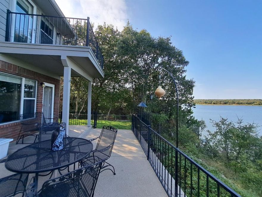 Beautiful waterfront home in gated Paradise Cove on Lake Whitney!  This well maintained 3 bedroom, 1.5 bath townhome offers gorgeous panoramic lake views from every room on the first floor as well as the primary bedroom and balcony on the second.  The open floor plan features a modern kitchen with quartz counters, a large island perfect for entertaining, and spacious living room with a gas burning fireplace.  Three walk in closets and easy attic access ensures ample storage.  The assigned parking, one car detached garage, and 2 boat storage stalls provide plenty of parking space for vehicles and watercraft.  The property is located adjacent to Juniper Cove Marina and boat ramp and is only a ten minute drive to the shopping and restaurants in Whitney.  The home is being offered fully furnished.  Don’t miss one of the best kept secrets on Lake Whitney!