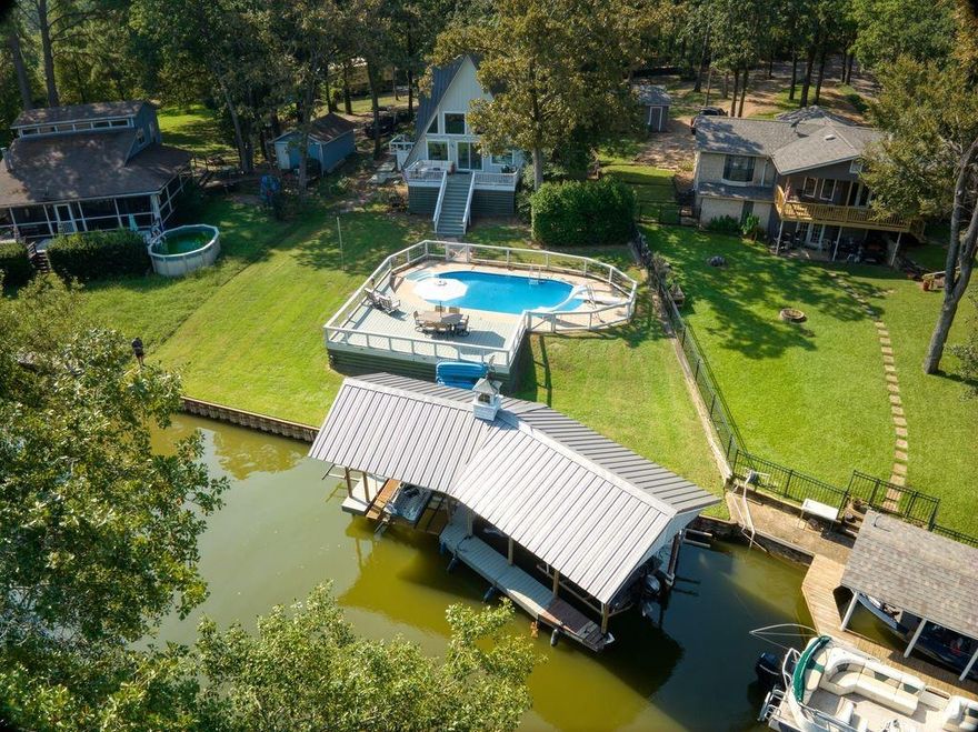 Discover the perfect blend of comfort and lakefront living in this beautifully updated, move-in ready home located on a peaceful private cul-de-sac. Enjoy direct lake access with your own private boat dock and lift, ideal for weekend boating or quiet evenings on the water.  Inside, the home offers a warm, cozy feel with thoughtfully designed spaces, updated finishes, and a layout that makes the most of the view of your own private oasis. The modern kitchen features stylish upgrades and plenty of charm, while the inviting living area is perfect for relaxing or gathering with friends and family.  The upstairs bunk room and guest bath provide a fun and comfortable retreat for children or visitors, giving everyone their own space to relax and enjoy lake life. Step outside to your backyard oasis—a sparkling pool, spacious patio, and tranquil views create a private retreat for year-round enjoyment.  Fully updated and ready for you to move in, this lakefront gem combines modern comfort with cozy charm in a truly special setting.  Pella windows throughout, an outdoor shower and large storage space under the deck are all great additions!!  Don't miss this one!