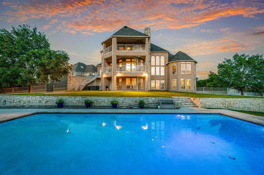 Stunning Three-Story Home with Breathtaking Eagle Mountain Lake Views. Nestled in a quiet cul-de-sac, this exceptional home offers panoramic views of Eagle Mountain Lake and unforgettable sunsets from every level. An oversized elegant resort style pool designed for both relaxation and swimming laps. This residence boasts floor-to-ceiling windows that flood the home with natural light while framing the serene beauty of the lake. The grand staircase serves as a striking architectural centerpiece, leading you through spacious living areas perfect for entertaining or relaxing. Primary suite with beautiful dual vanities. Open kitchen design. An elevator leads you to the game room with its own spectacular view of the pool and lake, ideal for hosting friends or enjoying peaceful evenings at home. Stay fit in your private home gym, then unwind on the patio as the sun dips below the horizon. Whether you’re enjoying a quiet evening or entertaining guests, the setting is nothing short of spectacular. This one-of-a-kind property offers luxury, privacy, and a front-row seat to some of the most beautiful scenery Eagle Mountain has to offer. Schedule your private tour today.