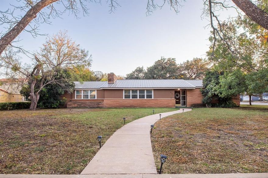 Take a look at this inviting brick ranch set on a spacious corner lot in the historic homes district of Brady. The home features a durable metal roof, a large yard, and beautiful live oak trees that create a peaceful backyard setting.

Inside, the updated kitchen stands out with its quality wood cabinets, and subway tile backsplash. The kitchen is also equipped with a large pantry with great storage for all your dry goods and additional small appliances. 

The property also includes a large garage along with a double carport, offering plenty of room for parking and stowing.

This home is comfortable, and spacious. Schedule a visit to see it for yourself.