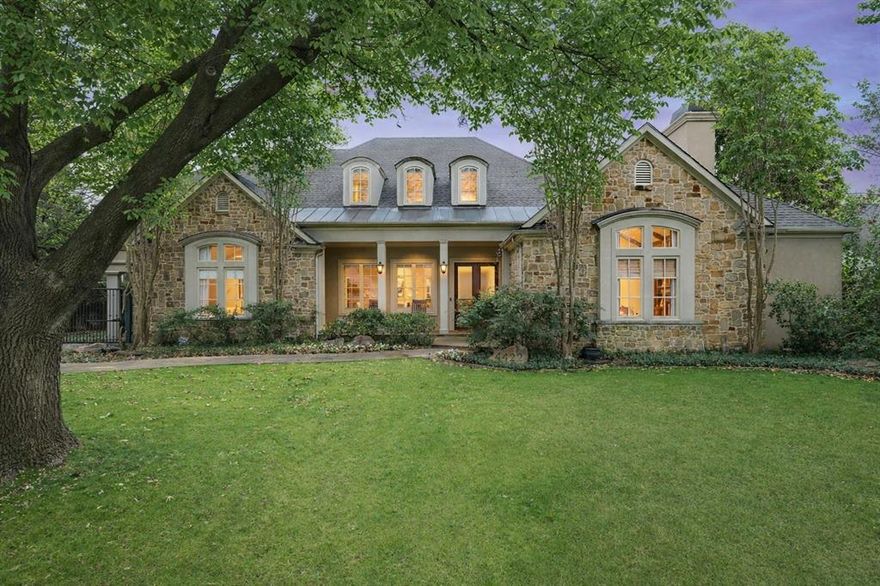 A rare opportunity to own a classic Bluffview estate on an exceptional .384-acre lot 100x165  in one of Dallas’ most sought-after neighborhoods. Surrounded by mature trees and established homes, this expansive property offers remarkable scale, privacy, and endless potential. The residence spans 5,588 square feet and was taken down to the studs in 2005, providing a strong architectural foundation for future customization. Generous living spaces and a thoughtful floor plan create an ideal canvas for renovation or re-imagining to suit today’s luxury lifestyle. The marble-appointed kitchen opens seamlessly to the main living area and breakfast nook, framed by floor-to-ceiling doors and windows that showcase stunning views of the beautifully landscaped backyard and flood the home with natural light creating a true indoor-outdoor living experience. The downstairs primary suite is a private retreat featuring a fireplace, over 500 square feet of substantial closet space, and tranquil backyard views. Two additional bedrooms on the main level offer flexibility for guests or home office use, with one bedroom providing direct access to the covered carport through a gated drive, a rare and convenient feature. Upstairs includes two additional bedrooms, along with a spacious game and media room complete with a kitchenette. The true highlight is the exceptional grounds, featuring a large pool, separate spa, water feature, built-in grill, and multiple outdoor living areas are ideal for entertaining or quiet enjoyment. With 100 feet of frontage and 165 feet of depth, the property presents a unique opportunity to enjoy as-is, enhance, or create a custom estate in a premier Bluffview setting. Properties of this size and setting are seldom available an outstanding land and estate opportunity in the heart of Dallas.