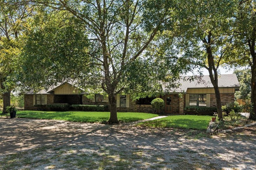 Escape to your own private oasis with this 4-bedroom, 2-bathroom ranch style residence nestled in the picturesque landscape of Weatherford. Designed for a relaxed lifestyle and an appreciation for nature, this property offers an idyllic blend of rural charm and modern convenience, complete with a breezeway and 2-car garage.

Step inside to discover an expansive floor plan highlighted by a spacious kitchen featuring granite counters, a large island with 2nd sink, and three pantries, perfect for culinary adventures and gatherings. The kitchen's open layout connects seamlessly to the dining room, with French doors, creating the perfect spot for al fresco dining.  A corner fireplace sets the scene for cozy evenings and gatherings in the spacious living room.  The primary bedroom serves as a true private retreat, complete with its own fireplace, and bay window. The secondary bedrooms have spacious closets and the utility room has space for two freezers.

Beyond the interiors, the property boasts extensive outdoor perks and opportunities for adventure. Both covered front and rear porches invite relaxation as you soak in the serene views of mature trees swaying in the breeze.  The covered rear porch has a built-in grilling fireplace. The landscape is accentuated by a stocked pond, perfect for leisurely fishing or contemplative afternoons by the water’s edge. For outdoor enthusiasts, a floating dock, classic windmill, and hilly terrain enhance the property's natural beauty.

Additional gems include a quaint guest cottage or home office, a horse barn with concrete aisle, and ample space for a thriving vegetable garden, catering to a sustainable lifestyle. This impressive residence is more than just a home; it is a sanctuary that balances natural beauty and striking terrain. Whether hosting friends for the weekend or finding your own peace in the presence of nature, this property offers a rare opportunity to experience relaxed country living at its finest.