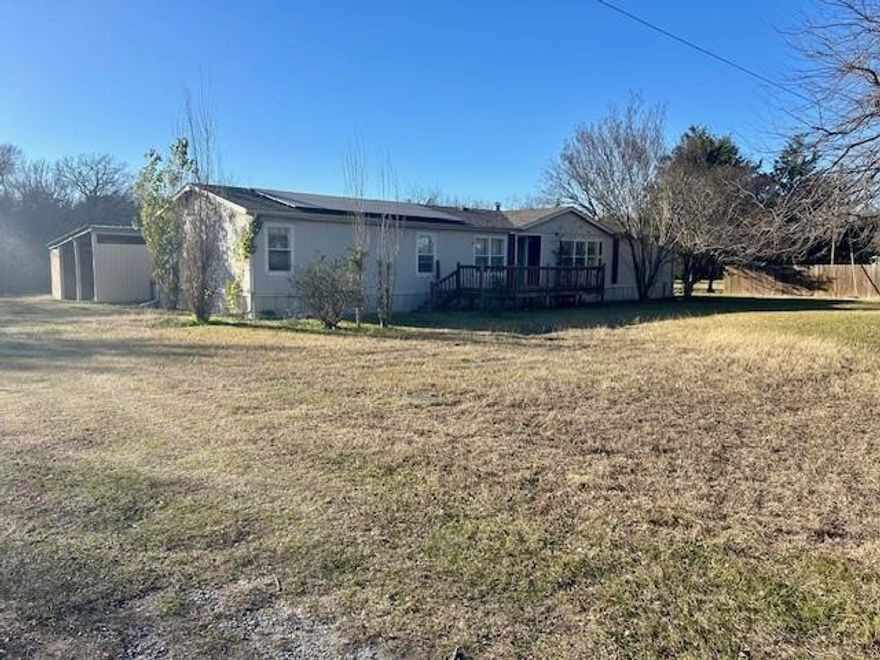 This 3 bedroom-2.5 bath manufactured home offers 2,200 sq. ft. of living space. It is sits on 4 beautiful acres! The kitchen features plenty of wooden cabinets great for storage and lots of counterspace. The large living room includes a fireplace and is semi open with the spacious kitchen and dining area.   The primary bedroom offers a walk-in closet and a large bathroom with garden tub and a separate shower. The primary room has privacy at one end of the house and the other 3 bedrooms and 1.5 baths at the opposite end. The property also includes an accessible deck-ramp, a solar panel system, and multiple outbuildings that enhance its functionality. Additional features include an auxiliary building suitable for a workshop or secondary unit, storage sheds, a large open-sided carport, and a covered multi-bay kennel with concrete runs. The main outbuilding is the dog kenneling building perfect for housing 12-20 dogs. The building is on concrete for easy cleanup and has water and electricity including a sink and cleanup area. The house and outbuilding areas are situated at the front of the property with most of the 4 areas deep and wooded to enjoy. The solar panel system keeps the average electric bill around 25 to 40 dollars a month! Can't beat that!! The home needs some TLC but you can't beat the beautiful land and great dog kenneling building. Call for your appointment today!