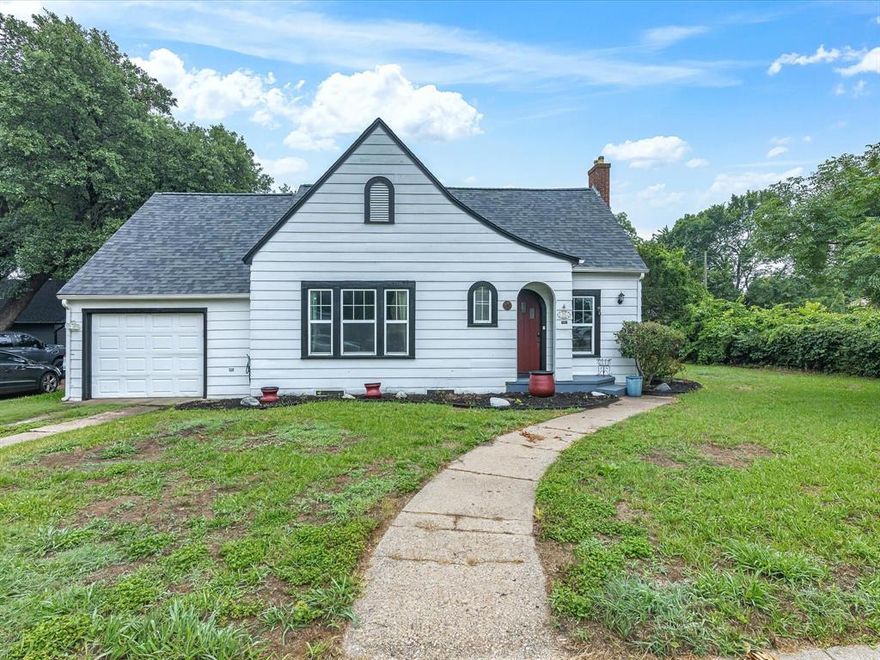 MOTIVATED SELLER!  Welcome to this charming Cottage-style Tudor home nestled in the heart of downtown Ennis. Bursting with character and warmth, this adorable and cozy residence offers the perfect blend of historic charm and modern comfort. Situated within walking distance to shops, schools, dining, and all that downtown has to offer, the location is unbeatable for convenience and lifestyle. Inside, you'll find two generously sized bedrooms and two full bathrooms, perfect for comfortable everyday living or entertaining guests. The spacious living area is a true highlight, anchored by a beautiful brick fireplace and surrounded by large windows that bathe the room in natural light. Original hardwood floors run throughout, adding to the home’s classic feel. The dining room, located just off the kitchen, features charming built-in cabinetry and its own bright atmosphere—ideal for family meals, hosting friends, or even transforming into a secondary living or reading area. The kitchen is both functional and stylish, featuring stainless steel appliances and ample cabinet space. A one-car garage is attached and includes a stackable washer and dryer for added convenience. Step outside to enjoy the back porch, a peaceful spot for morning coffee or evening unwinding. The backyard is a picturesque retreat, designed with a park-like setting—shaded, serene, and perfect for relaxing, gardening, or play. Whether you're a first-time buyer, downsizing, or simply seeking a beautifully maintained home with classic charm, this delightful Tudor cottage is a rare find in Ennis.