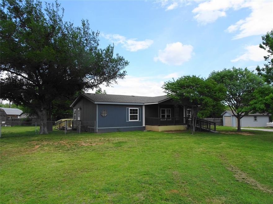 This updated manufactured home sits on a spacious lot in a relaxing setting yet is just minutes from Granbury square.  Recent improvements give the interior a modern, move-in-ready feel, while the open layout provides flexibility for your lifestyle. The expansive outdoor space is perfect for pets, hobbies, or future enhancements—there’s room for it all.  Ideally located near shopping, restaurants, and a park with a boat ramp, this property offers the best of both worlds: peaceful living and everything you need just moments away.  Recent improvements include a new 300+ sq. ft. deck in back, new windows, freshly painted exterior and interior, new roof in 2024, and more.  The primary bathroom features a walk-in tub to sooth your aching muscles. One bedroom is currently set up as an office but can easily be reconfigured.  The garage offers workshop space and secure parking.  Some touch up painting is ongoing.  New countertops just installed.  Backsplash work is underway.
