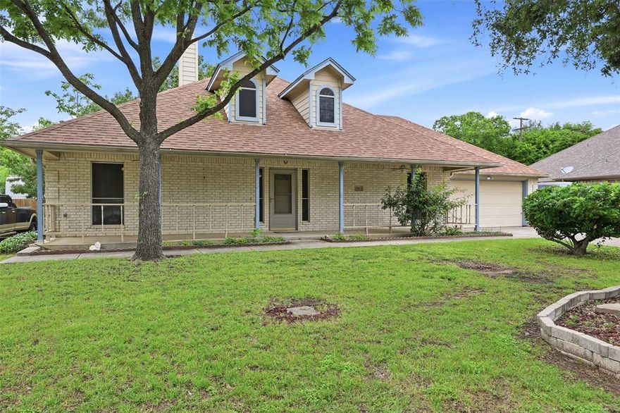 Welcome to this well designed 3 bedroom, 2 bathroom home offering a functional layout, versatile spaces, and standout outdoor living in an established Richland Hills neighborhood.

From the moment you arrive, the full length covered front porch sets the tone with a welcoming entry and added accessibility. Mature trees and established landscaping provide shade, character, and a sense of comfort that’s hard to find.
Inside, the spacious living room is anchored by a brick fireplace with built-in shelving, creating a natural focal point with both style and function. Bamboo flooring flows through the main living areas, adding warmth and continuity throughout the home.
The kitchen sits at the heart of it all, featuring ample cabinetry, generous counter space, and a gas range with stainless steel appliances. Just off the kitchen, a bright breakfast nook brings in natural light and creates an inviting everyday dining space. A separate dining room offers flexibility for gatherings, a home office, or additional living space.
The enclosed sunroom provides a bright extension of the home, ideal for relaxing, hobbies, or a second living area. The split bedroom layout adds privacy, with the primary suite offering dual sinks, a separate tub and shower, and accessibility features.
Step outside and discover where this property truly shines. The courtyard style patio creates a private outdoor retreat, while the expansive backyard offers endless possibilities. A pergola covered patio is perfect for outdoor dining or entertaining, surrounded by mature trees that enhance both beauty and shade.
In addition to the attached two car garage, the property includes a detached garage or storage building along with a dedicated workshop space, giving you room for projects, hobbies, or additional storage.
With its thoughtful layout, unique character, and rare combination of indoor and outdoor living spaces, this property offers flexibility and functionality to fit a variety of lifestyles.