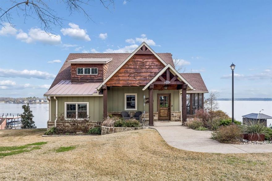 Introducing 29 Shoreline, an exceptional custom home completed in 2020 sitting on a double lot with approximately 142 feet of prime waterfront in the  Star Harbor Community. No detail overlooked, this home offers 3 bedrooms, 3.5 bathrooms, and was thoughtfully designed and built with indoor-outdoor living in mind. The main level welcomes you with an airy open-concept kitchen, living, and dining area, custom woodwork throughout, and a stone gas fireplace. Expansive windows frame the water views, while seamless access to both a screened-in side porch and a covered back porch creates multiple spaces for entertaining and relaxing. The primary suite is privately positioned on the main floor, complete with a spa-like ensuite bath.
Downstairs, you’ll find two oversized guest bedrooms, each with access to their own full bathrooms, along with a generous laundry room complete with tons of storage. A spacious family room with wet bar provides the perfect setting for hosting family and friends after a day on the water. Step outside to enjoy a fully fenced backyard surrounded by mature trees and enhanced by landscape lighting. The outdoor living experience continues with a covered outdoor kitchen and additional covered patio space, ideal for year-round enjoyment. At the shoreline, a two-stall boathouse with sun deck features electric boat lifts, electric covers, and WiFi — blending convenience and luxury for true lakefront living. Golf cart garage, mosquito misting system, tankless hot water heaters, and much more! Highly desirable Star Harbor community features a 9 hole golf course, deep water boat launch, with a great mix of full time residents or weekenders! This area of the lake is known for some of the deepest water and preferred for boating, surfing, and float fun!