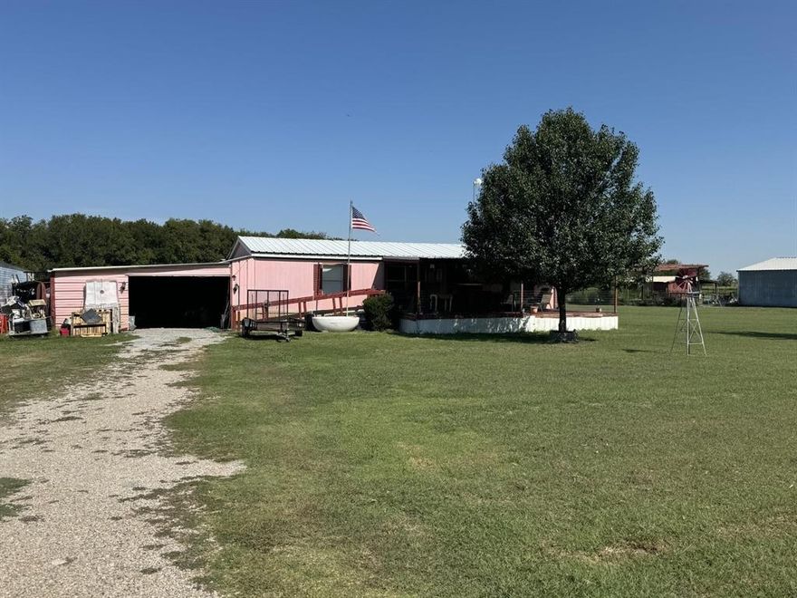 Wonderful location in the country but close to the city and easy access to I35. Bring your TLC and your horses. Freight container stays, three sides are fenced, covered front porch to enjoy morning coffee or evenings.  Plenty of room for a pool or room to park your RV. This diamond in the rough just needs you to put your touch on this property where the mobile home title has been surrendered and is attached to the land.  Has eat in kitchen with breakfast bar and separate dining room.  Fairly open floor plan with living area, dining and kitchen also with split bedrooms. No Restrictions Property is sold AS IS  
Seller is keeping Fridge