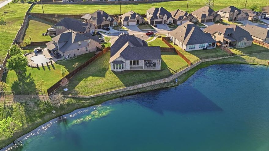 Experience timeless elegance in the heart of North Texas & just minutes away from the quaint historical dining town of Roanoke where the thoughtful design, upgrades galore, & luxurious finishes come together to create an exceptional living experience. From the moment you step inside your breath will be taken away by the outstanding view of the upgraded expansive back covered cedar beamed stone patio w two ceiling fans, outdoor kitchen & grill, hot tub & the floating decorative lighting fountain beaming in from the expansive windows in the livingrm. From the sprawling staircase to soaring ceilings the 20 ft. stained cedar beam stretching across the ceiling adds an extra WOW to the livingrm along with floor to ceiling designer stone gas fireplace. Gourmet chef kitchen boasts section of wine lattice w wine refrig., granite counter tops, moon white cabinetry to the ceiling, shaker wood vent hood w Mission Corbels spice drawer pull outs, deep pot & pan drawers, recycle bin, two glass lighted cabinets w glass shelves, LED under cabinet lighting, soft close drawers, cookie sheet divider, slide out tray, huge walk in pantry, & more! Primary suite is a serene escape overlooking the lighted fountain on the lake w ensuite spa inspired jetted tub, oversized shower, separate vanities, & custom designed closet. Downstairs has guest bedrm, full bath, dining rm, & designated office w french glass doors. Upstairs, you'll find media rm w equipment, game flex room, two bedrms, & full bath. Short drive to upscale shopping in Southlake, golf courses, lakes, DFW airport. & perfectly positioned within the Northwest ISD. Reel in this beauty today. BEST part is this home is ready to make it your own catch. Imagine stepping into your backyard paradise, casting a line, & enjoying the peaceful lake view with lighted ambiance in the evening every day & night. Don't let this one slip away! Community offers walking biking trails meandering around catch release fishing lakes, pools, & playgds.