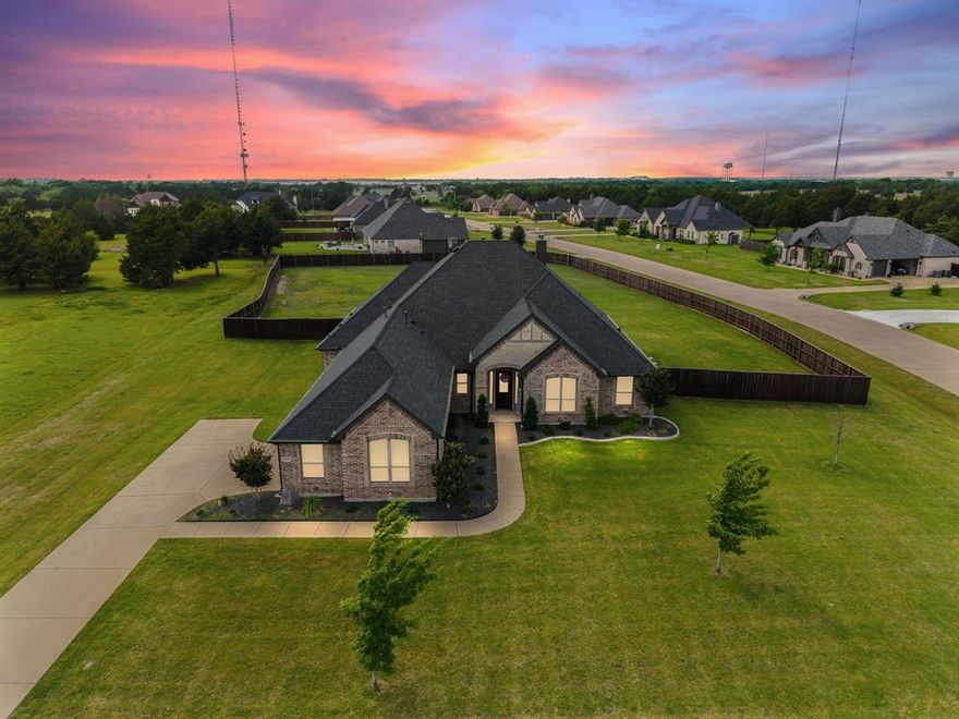 Dream home on a corner lot with 1.3 acres of serene, expansive landscape in the heart of Midlothian! This beautifully designed one-story home truly has it all, offering 4 bedrooms, a dedicated office, and 3 spacious living areas, including a main living room, game room, and an oversized bonus room perfect for a gym, media room, or flexible living space. The fantastic floor plan centers around an inviting kitchen, living, and dining area ideal for everyday living and entertaining. The chef’s kitchen features a gas cooktop, double ovens, abundant counter space, and a large island, all opening to the dining area and a vaulted living room with a cozy fireplace and views of the covered patio and expansive, landscaped backyard. The private primary suite is a true retreat with a sitting area and spa-like bath featuring dual vanities, a walk-in shower with dual shower heads, and a large walk-in closet. Thoughtfully designed, two secondary bedrooms share a Jack-and-Jill bath, while the fourth bedroom includes its own ensuite, perfect for guests or multi-generational living. Enjoy the peace and privacy of acreage living with room to roam, garden, or add a pool, enhanced by an extended sprinkler system covering the front flower beds and fence line. Major improvements include a new roof and upgraded gutters in Oct 2022, a whole-home water softener, JellyFish color-changing exterior lighting, REME Halo whole-home air purification system, Guardian floor coating in the garage and bonus room, a mounted smart TV in the bonus room, a fully fenced yard and an upgraded gas fireplace with a glass screen and remote control operation. Located within highly regarded Midlothian Independent School District and offering convenient access to shopping, dining, and an easy commute to Dallas or Fort Worth, this property delivers the perfect blend of comfort, function, and relaxed country living with city conveniences! Schedule your showing today!