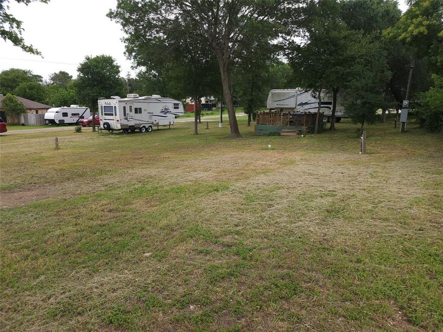 Situated on a spacious corner walking distance to Lake Whitney, this versatile property is ready for your weekend getaway, full-time living, or future homesite.  Improvements include electric service with both 30 and 50 amp hookups, electric pole in place, septic system installed, and water already on the property with multiple water spigots for convenience.  Two campers will convey with the property, including one that is currently livable.  Plenty of room to expand park additional RVs, or build to suit.  A great setup with utilities already in place and endless potential.