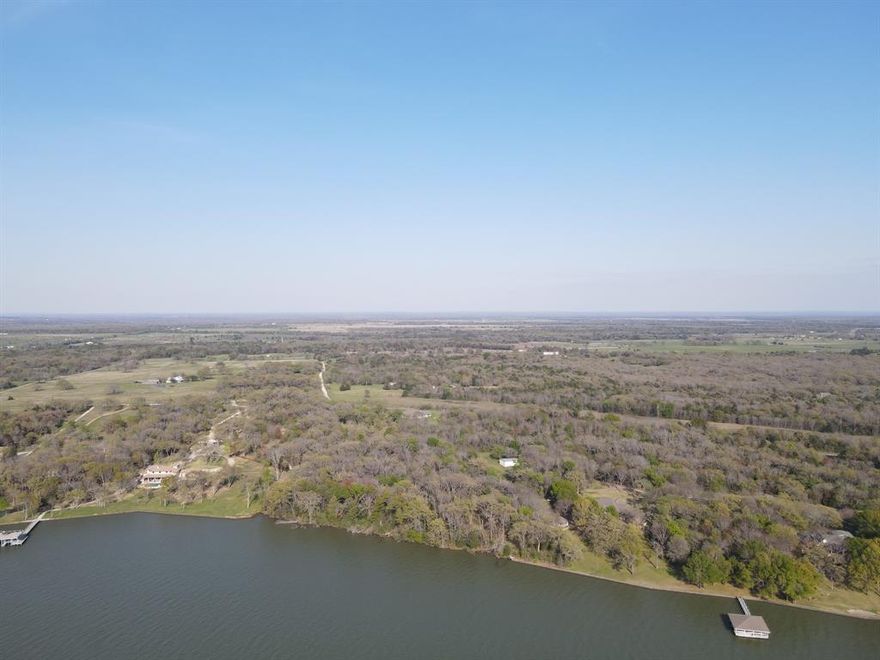 This non restricted 9.76 acre parcel features 550 feet of shoreline located on the Kerens side of Richland Chambers Lake, perfect for a privately accessed residential retreat, or even a place to develop into something for an income stream! The seller has recently created a cut path half way through the acreage and from there, you can make your way to the water. With no restrictions to hold you back, this is the perfect place to bring your water front dream to life. Electric and water are nearby already. The heavy wooded areas ensure that no matter what you decide to remove, you'll still have privacy and seclusion if you wish. The 550 feet of unrestricted shoreline is rare, so don't limit your imagination! Beautiful sunrises over open water at Richland Chambers Lake just can't be beat. Excellent fishing and boating opportunities and there are 2 public boat ramps within 10 minutes...or you can build your dock to launch from! So bring your boots and come explore this raw and ready parcel!