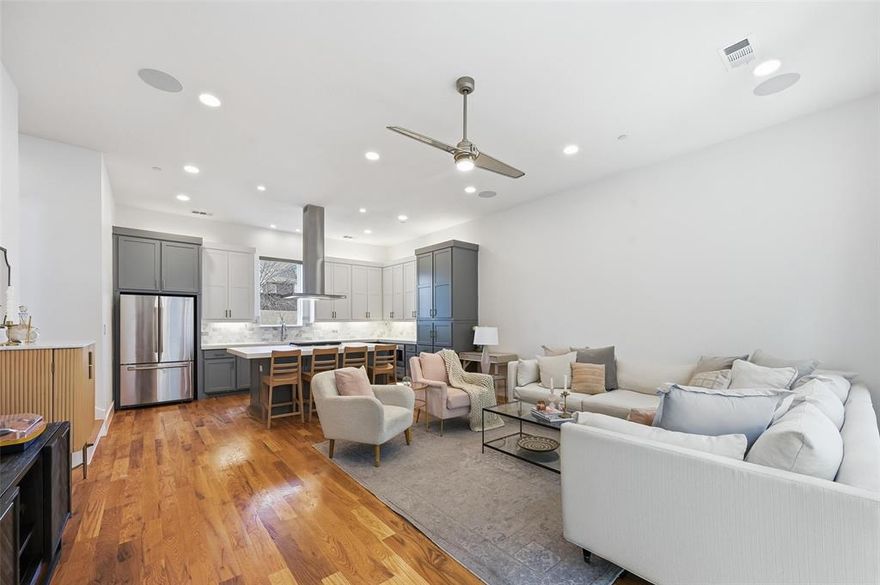 Live at the center of it all in this modern Dallas condo, perfectly positioned at the intersection of Greenville and Henderson—one of the city’s most vibrant hubs for dining, nightlife, and entertainment. This three-story residence blends contemporary style with effortless city living.
Inside, the home features soaring 11-foot ceilings, warm wood floors, and dramatic walls of windows with electric shades that create a light-filled, elevated atmosphere. The open second floor is made for entertaining, anchored by a show-stopping kitchen with a massive island, sleek cabinetry, and exceptional storage. A half bath on this level adds everyday convenience. Both bedrooms offer private ensuite bathrooms and walk-in closets, ideal for roommates or guests. The primary suite feels like a hotel retreat with dual vanities and an oversized shower featuring statement waterfall shower head. Rounding out the lifestyle appeal is a private, fenced yard with lighting and low-maintenance pavers—perfect for pets, hosting friends, or unwinding. An attached two-car garage and gated community with electric access complete this lock-and-leave urban oasis.