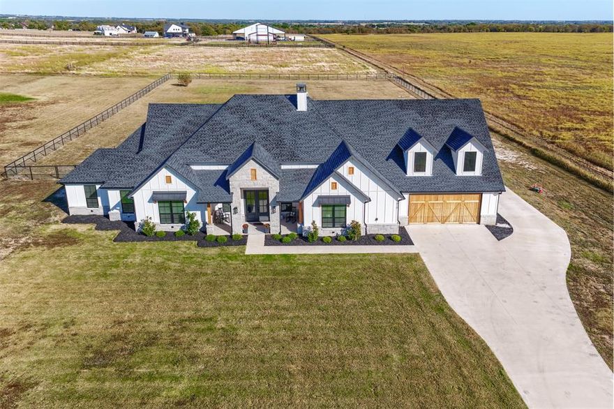 Welcome to 1810 J.C. Maples Rd in Gunter—a true Texas gem loaded with upgrades inside and out! Set on 1.78 acres, this beautifully designed 4-bedroom, 2.5-bath home offers two spacious living areas, a private study, and a 6-car garage built for those who need room for everything. Step inside and be wowed by the open layout, split-bedroom design, and stamped concrete flooring throughout. The chef’s kitchen steals the show with a commercial-grade 6-burner cooktop and built-in grill, drop sink, custom cabinetry, and a massive island perfect for cooking, gathering, and entertaining. Out back, experience outdoor living at its finest—a built-in kitchen, stone fireplace, and even a putting ring for golf enthusiasts. The east-facing backyard means cool shade in the evenings, ideal for relaxing or hosting summer get-togethers.
This home delivers luxury, functionality, and Texas charm all in one—the most sought-after floor plan in the state, upgraded top to bottom. Don’t miss this one-of-a-kind property built for those who want it all!