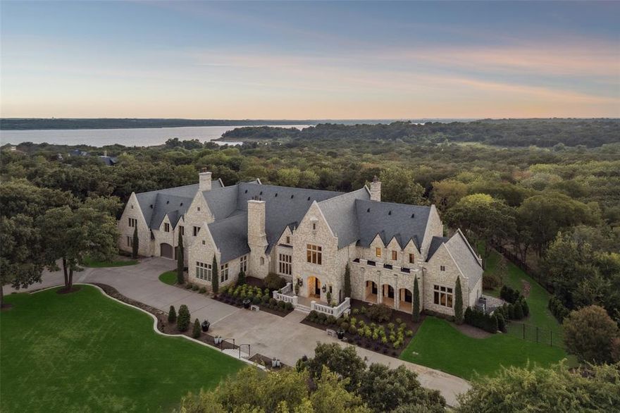 Welcome to this exceptional luxury estate in the highly coveted, gated community of The Landing on the North shore of Lake Grapevine—where refined elegance meets everyday luxury, spanning across 2 pristine acres. Recently reimagined with an extensive interior and exterior renovation, this architectural masterpiece blends classic European sophistication with the finest modern amenities. Beyond the new slate roof and striking black-framed windows, an all-new resort-style backyard awaits. From the stunning new pool and elevated spa to dramatic fire features, a serene loggia, and lighted stone steps, every inch has been thoughtfully curated for private outdoor entertaining. Mature trees provide year-round seclusion, with the home backing to a protected Corps of Engineers nature preserve—ensuring lasting privacy and serenity. Inside, expansive living spaces unfold beneath beamed and coffered ceilings, anchored by a grand family room overlooked by mezzanine sitting area with Juliet balconies and exquisite lighting. The chef’s kitchen is a showpiece—fully updated and outfitted with premium appliances and custom finishes. A romantic owner's retreat features vaulted ceilings, sitting area, fireplace, and a newly redesigned primary en-suite bath with dual custom closets and an in-suite washer and dryer. Additional luxuries include a formal executive study with fireplace, a spacious home gym, and a separate living quarters—ideal for guests, multi-generational living, or a private studio. Car enthusiasts will appreciate the 2,850 sq ft heated garage space. With fresh designer paint inside and out, all-new landscaping, and exquisitely reimagined interiors—including a showstopping kitchen —this estate delivers the ultimate in turnkey, resort-style living. A true crown jewel, this irreplaceable legacy estate fuses timeless architecture, unparalleled privacy, and world-class amenities to stand among the most iconic luxury properties in all of North Texas.