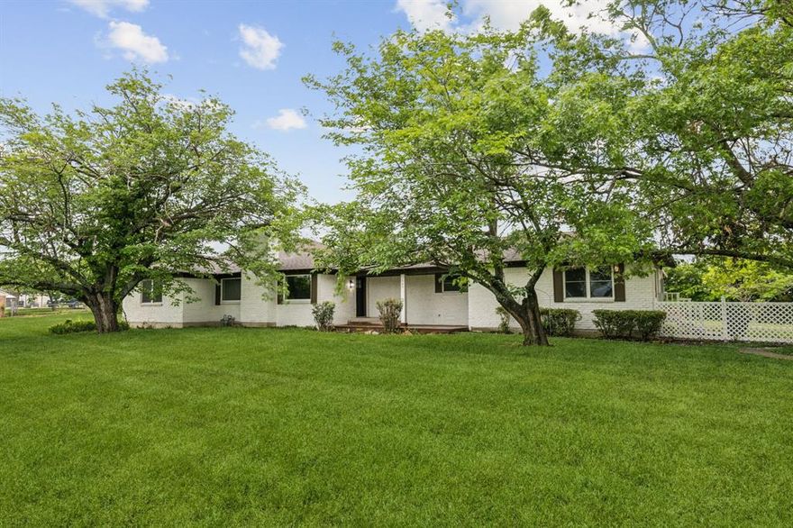 Impeccable Single-Story Home on 1.21 Acres in Rockwall! Nestled among mature trees, this beautifully maintained home sits on a spacious 1.21-acre lot and offers the perfect blend of comfort and style. Step inside to an expansive living room featuring a stunning floor-to-ceiling brick fireplace and double windows that provide picturesque views of the serene backyard. A second living room also boasts a floor-to-ceiling brick fireplace—ideal for cozy evenings or entertaining guests. Plank hardwood floors flow seamlessly through the main living areas, enhancing the home's warm and inviting atmosphere. The amazing kitchen showcases two-tone cabinetry with gray lowers and crisp white uppers, complemented by brand-new 2025 stainless steel appliances including an electric cooktop, built-in oven, and microwave. Enjoy casual meals in the sunny breakfast nook or host gatherings in the large formal dining room, complete with sliding glass doors that open to the expansive backyard patio—perfect for outdoor dining and summer BBQs. The generously sized primary suite features plush carpeting, private doors that open directly to the backyard space, and a spa-inspired en-suite bath with a standalone soaking tub, separate shower with gorgeous stone surround, and dual vanities. This home also offers three spacious guest bedrooms and two beautifully updated guest bathrooms, providing plenty of room for family and visitors. Additional highlights include a large utility room with space for a workstation or pantry and an oversized garage. Outside, the huge grassy yard offers plenty of room to play, garden, or even add a future pool. This property is a rare find—don’t miss your chance to call it home!