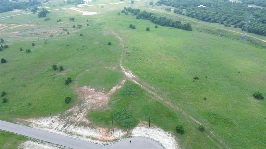 This exceptional 5-acre parcel is situated just beyond the city limits of Alvord in The Ranches at Rolling Hills, offering impressive views of the surrounding landscape. The property features gently rolling slopes both at the front and rear, providing an elevated vantage point overlooking the lowlands of the ranches. Bardominiums are permitted, and the potential exists for panoramic vistas from a custom-built country residence. Conveniently located approximately 50 minutes from downtown Fort Worth, this lot presents an ideal opportunity to construct your dream home. High-speed fiber internet is available at the street. Additionally, owners have access to 250 acres of the scenic LBJ Grasslands, which offer a variety of recreational activities including fishing, hiking, and more.