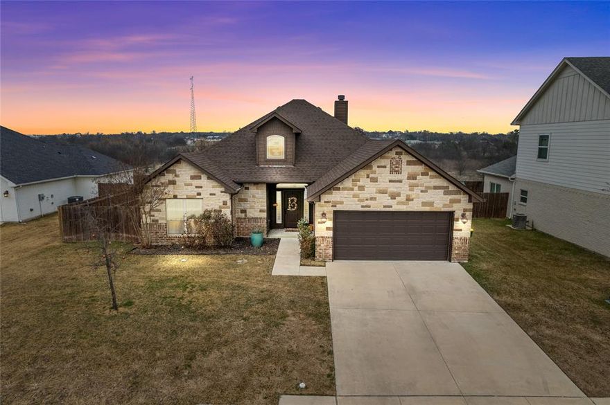Hello Darling! Welcome to this beautifully well-maintained home in the Godley Heights neighborhood of Godley, Texas, where rustic charm and warm finishes create an inviting, comfortable atmosphere. The open-concept living area is anchored by a cozy brick fireplace with custom built-in shelving, offering both character and functional display space. Wood-look flooring flows throughout the main living areas, complementing the neutral tones and enhancing the home’s timeless appeal.
The spacious living room provides plenty of room for gathering and relaxing, with crown molding, recessed lighting, and ceiling fans adding comfort and style. Large windows fitted with plantation shutters allow natural light to fill the space while offering privacy and energy efficiency.
The kitchen is thoughtfully designed with white cabinetry, granite countertops, stainless steel appliances, and a generous center island with seating—perfect for casual meals or entertaining. A bright dining area sits just off the kitchen, highlighted by modern lighting.
Bedrooms are well-sized and welcoming, featuring plush carpet, ceiling fans, and warm color palettes. The primary suite offers a relaxing retreat, while secondary bedrooms provide flexibility for guests, home office space, or hobbies. Bathrooms are clean and well cared for, showcasing granite countertops, ample cabinetry, and tasteful finishes.
Every corner of this home reflects pride of ownership, from the detailed trim work to the cohesive design choices throughout. Nestled in a quiet, friendly neighborhood with small-town charm, this home offers comfort, warmth, and quality—ready for its next chapter. Come take a look before this one is G-O-N-E.