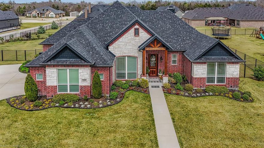 Welcome to this exquisite custom home where luxury, comfort, and thoughtful design come together beautifully. Nestled on a meticulously landscaped 0.48 acre lot, this impressive three bedroom, three bathroom home offers an inviting open concept layout complemented by soaring vaulted ceilings and rich hand scraped hardwood floors that flow gracefully throughout the main living spaces.

Step inside and experience a home filled with natural light, where expansive windows highlight the exceptional craftsmanship and refined finishes found throughout. The gourmet kitchen is truly the heart of the home, featuring elegant granite countertops, premium appliances, abundant cabinetry, and a spacious island designed for effortless entertaining and casual gatherings.

The generous living area offers the perfect setting for both relaxation and hosting guests, while a dedicated study or home office provides a quiet and comfortable space for work or reading. Each of the three bathrooms is beautifully appointed with granite countertops and quality fixtures that blend style with everyday functionality.

The spacious primary suite serves as a private retreat, offering a serene atmosphere and spa inspired amenities designed for ultimate relaxation. Two additional bedrooms provide comfort and privacy for family members or visiting guests.

A two car garage offers both convenience and additional storage, while the outdoor living space elevates the home even further. Step outside to your own backyard sanctuary where a fully equipped outdoor kitchen invites year round entertaining on the covered patio. The lushly landscaped yard provides ample room for outdoor gatherings, gardening, or simply enjoying the peaceful surroundings.

This remarkable home showcases custom craftsmanship, elegant finishes, and exceptional livability, creating a truly special place to call home.