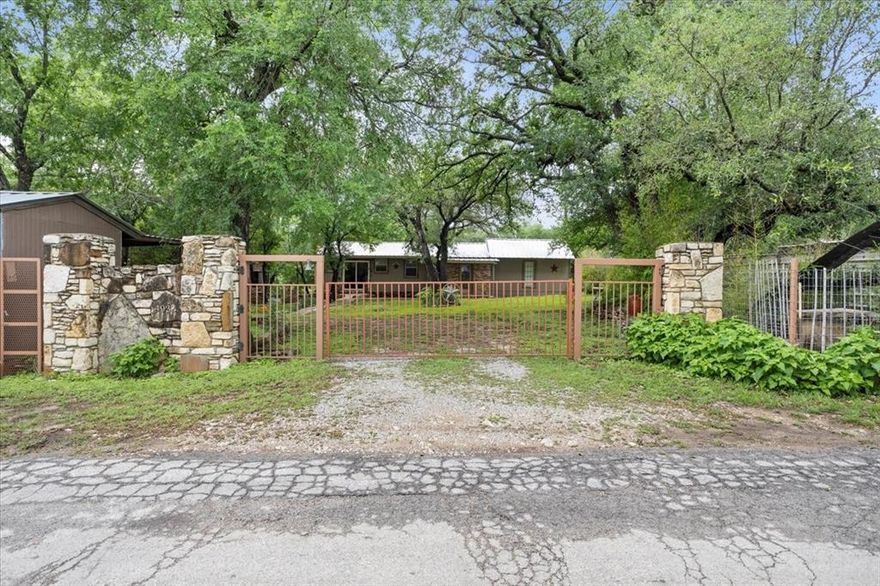 Discover serenity and convenience in this charming 2-bedroom, 1-bathroom cabin, nestled in peaceful Western Lake Estates near the two private lakes with easy access to a boat launch. Ideal for those who relish outdoor activities as well as homely comforts, this property offers the best of both worlds. With 1001 square feet of living area, this residence boasts a thoughtfully designed interior with a beautiful wood burning fireplace. The natural rock accents throughout the home add the perfect touch of warmth. Each bedroom radiates comfort and style, providing a private oasis after a long day's activities. The heart of the home, the kitchen, is uniquely located outside, perfect for enjoying warm, Texan evenings or hosting delightful gatherings under the stars. Fully equipped with all necessary appliances, this kitchen is the perfect place to whip up delicious meals. Security won't be a concern as the property is fully fenced and gated, offering peace of mind and privacy. Additionally, this cabin comes fully furnished, making the move-in process as seamless as possible — just bring your suitcases! All furnishings seen in the pictures convey with the purchase. This cabin is not just a dwelling but a lifestyle choice. Whether you're a nature lover eager to explore local waterscapes or someone who appreciates the charm of alfresco dining at home, this property promises to cater to all your whims with functionality and ease. Step into a life of tranquility and convenience, wrapped up beautifully in a home that's ready to create unforgettable memories. Whether you want to visit paradise on the weekends or live in it every day, this is the place for you!