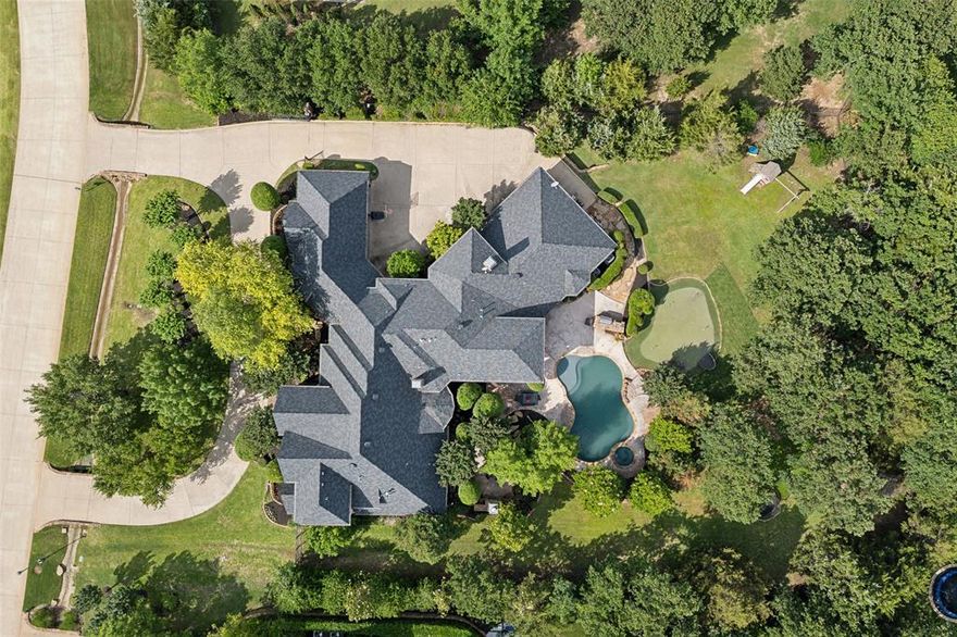 OPEN ENROLLMENT TO CARROLL ISD! SPECTACULAR estate with show stopping curb appeal!!!  Situated on a heavily treed one acre lot w lush landscaping & a cascading water feature in front yard to greet you & your guests!  Beautifully updated kitchen offers quartz countertops, new cabinetry, large center island, SS appliances including a dbl refrigerator freezer and new light fixtures.  The primary bedroom suite offers a private sitting room, large spa bath, fireplace & romantic cove lighting!  The executive study is set apart great for working from home.  This dreamy home even features a basement wine cellar, perfect when entertaining.  Guest ensuite down, Upstairs features 3 en-suite bedrooms, a game room, separate Media room & abundant storage closets.  A true Backyard Oasis offering a pool and spa, built-in grill station and a putting green! Located in the highly coveted Clariden Ranch with walking distance to the 700 acre Bob Jones Nature Preserve w Sports Complex & Equestrian trails.