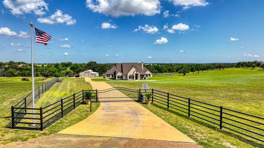 Discover your dream retreat in this stunning custom-built luxury home! Ideal for those seeking tranquility while remaining close to all conveniences, this property has it all! This property sits back off a private road located within two gates offering both privacy and security, this 4400 square foot ranchette features a sprawling 14.66 acres and spacious pasture for horses and cattle with potential for expansion. Attached 4 car garage and the extra-large barn includes 2 horse stalls with runs, automatic watering, and space for additional stalls. It also boasts ample storage and paved parking as well as RV parking and large workshop area. The barn's tack room is equipped with air conditioning and heating. This custom home showcases countless upgrades such as hand scraped hardwood floors throughout, chef's kitchen with double island, quartzite countertops, Thermador appliances, two dishwashers, two ovens,2 refrigerator's an expansive working pantry, and a open floor plan that extends outdoors for year-round entertainment. Each of the four bedrooms has an ensuite bathroom and the media room or game room that could serve as a fifth ensuite bedroom, separate office with double glass doors and private patio access. Outside, the views are gorgeous, featuring a modern, heated play pool, spa, gas firepit, covered outdoor kitchen, patio living with corner fireplace, stocked fishing tank, lush pasture and beautiful trees. Additionally, the home has an indoor safe room designed for the unpredictable Texas weather. For those desiring to escape urban life without sacrificing luxury, this property is a must-see and currently has an Ag Exemption. No HOA,NO WATER BILL, ONE OF A KIND! New shingles on the roof July 2023