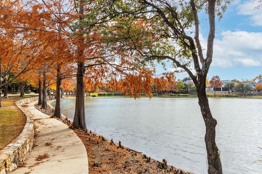 Step in from the Farmhouse exterior into the classically designed interior of this former Parade of Homes luxury property in the sought-after gated Lakes on Legacy Community! Take in the tranquil views of the neighborhood lakes from the expansive front porch and then be greeted by the grand foyer as you enter the home. The great room showcases an impressive wall of stone with a gas fireplace, two sets of French doors with water views, and hand scraped oak wood floors all beneath 100+ year-old reclaimed pine beams. Opposite that you'll find the elegant formal dining room with adjacent butler's pantry leading to a true chef's kitchen. Relish entertaining with the top-of-the-line and professional grade appliances in this natural gathering spot for family and friends boasting beautiful porcelain counters. Flow into the comfortable family room featuring 12-ft ceilings, Venetian plaster walls, cast stone fireplace, more hand-scraped oak floors and a wet bar with hammered copper sink. The handsome study is perfect for focused work or indulgent relaxation with extensive wood paneling, glass-front cabinetry, Ralph Lauren designer carpet, and French doors with more water views. Retreat to a serene primary suite with bay windows overlooking the lush backyard. The luxurious bath features travertine slab counters, jetted tub, frameless shower, dual sinks, and even a vanishing vanity mirror TV! The second floor has so much to offer including 3 bedrooms & 3 full baths (two are en-suite), a large game room with wet bar, a wonderful media room, and a loft office with two workstations, ample cabinetry & a skylight. A tropical paradise awaits you as you step out back to what is a true outdoor living space. Cool off and enjoy the sparkling saltwater pool with spa, several water features and full pool bath off the covered patio. The thought and care put into every aspect of this professional designer's personal home must be experienced to be fully appreciated!