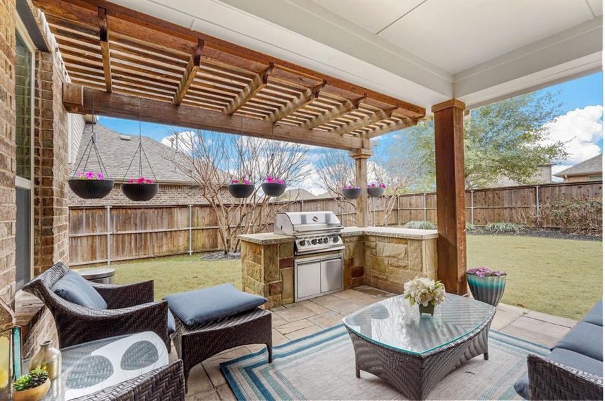 ! Stunning North-Facing Former Model Home in a Prime Location! Ideally situated near a community pool and clubhouse with a greenbelt view bursting with wildflowers in the spring and summer, this home is loaded with upgrades! Inside, enjoy tray ceilings, accent walls, and a striking stone fireplace. The chef’s kitchen boasts a huge island, gas cooktop, double ovens, and stylish backsplash. A wall of windows floods the open floor plan with natural light, overlooking the lush backyard, covered patio, and outdoor kitchen—perfect for entertaining! The luxurious primary suite features a spa-like ensuite with dual vanities, a soaking tub, and glass-framed shower. Within the primary suite there is a bonus room with a wooden accent wall- perfect space for a nursery, private gym, or sitting area. Downstairs, a home office with a stone accent wall adds style and function. Upstairs, enjoy a built-in workspace, extra living space, and a massive game or media room with a wet bar, mini fridge, and projector setup—all included! Additional highlights: paid-off solar panels with warranty, central speaker system in the living area, primary bedroom and game room, and solar exterior lighting. Located in Trinity Falls, enjoy resort-style amenities including pools, parks, trails, disc golf, and more. With easy access to Hwy 75, Downtown McKinney, shopping, and dining, this home is a must-see!