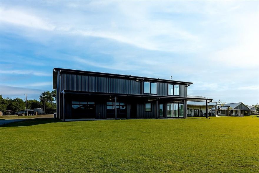 $20,000 in builder credits! Stunning luxury barndominium! This waterfront gem boasts high-end finishes and custom details throughout. The main level showcases a gourmet kitchen with solid Kentucky white oak cabinets, built-in 6-burner range, ice maker, solid surface counters, and an oversized island. The spacious laundry room includes a full wall of cabinetry, sink, and generous counter space. A half bath is conveniently located off the garage entry. The primary suite features a walk-in closet with a built-in gentleman’s dresser, plus a spa-like bathroom with a freestanding soaking tub and custom tiled walk-in shower with seamless glass. The living room frames breathtaking water views. Upstairs offers a massive game room, three more bedrooms, and three full bathrooms—each with luxury plank flooring, custom cabinetry, and tile showers. The 1680 sq ft garage includes fireman-style doors on the waterfront side and is fully temperature controlled.