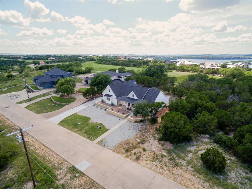 Live elevated at this new built 3-bedroom, 2-bathroom retreat designed to capture the beauty of the Palo Pinto Valley in The Cliffs Resort, one of the most coveted gated communities on Possum Kingdom Lake. This location is one of The Cliff’s best kept secrets that not only blows you away with the impressive views but also sits directly on the golf course. From the moment you arrive, you're greeted with modern farmhouse curb appeal and a covered front patio perfect for morning coffee. Inside, vaulted ceilings with exposed beams and polished concrete floors set the stage for effortless sophistication. The kitchen dazzles with granite countertops, a kitchen island, walk-in pantry, floating shelves, and striking black and gold finishes. The split-bedroom layout ensures privacy for guests, while the expansive primary suite offers a spa-inspired bathroom and massive walk-in closet with direct access to full laundry room. Full use 2 car garage with smart remote opener, natural light window, and side entry. Outside, the covered back patio opens to golf course views, an ideal setting for quiet evenings or possible future poolside entertaining. Enjoy world-class amenities which includes 36 rounds of golf a year, a full service marina, onsite security, community swimming pool, clubhouse, restaurant, fitness center, and tennis courts. This is more than a home, it’s a luxury lifestyle on the lake.