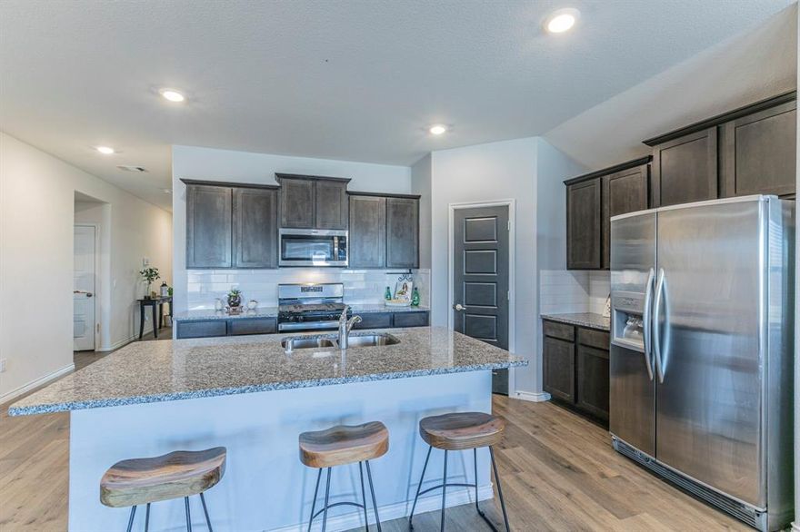 PRICE IMPROVEMENT!! Welcome to this lovely 4-bedrooms, 2-bathrooms, single story brick home located in a N. McKinney newer development (homes built between 2023-2025). It's a popular country meets suburban setting and sits in the highly sought after Melissa Independent School District. Offering over 1800 sq ft of living space this house opens to an airy layout where wood-like laminate plank floors sweep through the entrance into the kitchen, dining, & family living areas, perfect for family gatherings and everyday living. The natural sunlight creates a warm & inviting atmosphere in your modern kitchen, that includes granite counter tops, stainless steel appliances, eat-at island and a large walk-in panty for all your storage. 3 bedrooms are located in the front of the house, & one could easily function as a study, playroom, or quiet room for those serene moments we all savor. The primary bedroom is a great size & positioned in the back of the house for privacy. Large windows to brighten the room & the en-suite that includes dual sinks, stand alone shower, linen shelving, & an ample walk-in closet. The energy efficient Low-E windows and programable thermostat helps you keep your rooms temps where you want them. The spacious 2-car garage provides plenty of room & has a classy epoxy floor & it's where you find your tankless hot water heater for those endless showers. Step outside to a large fenced backyard-perfect for relaxing and enjoying your morning coffee on the covered patio & spend evenings grilling or just enjoying the backyard. This home combines comfort, style and an exceptional location. It's minutes from US-75, and accessible to shopping, dining and parks. Come See!