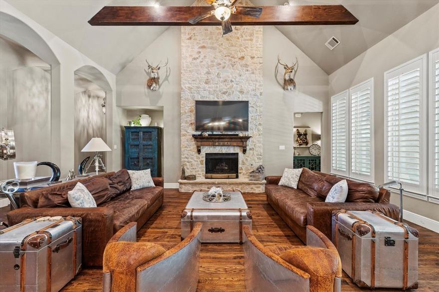 Experience this expansive, single-story custom home by M. Christopher, ideally situated on a serene 1-acre lot within the highly acclaimed Lovejoy ISD. Step inside to find rich hardwood floors and an exceptional floor plan that effortlessly blends style and functionality. Just off the entry, French doors open to a private home office featuring built-in cabinetry and a custom desk—perfect for remote work or study. At the heart of the home, the open-concept living area showcases soaring vaulted ceilings with wood beams and a striking floor-to-ceiling stone fireplace, creating a warm and welcoming space for gatherings. The gourmet kitchen is a chef’s dream, equipped with sleek stainless steel appliances, granite counter-tops, gas cook-top, double ovens, under and upper cabinet lighting, and a large center island. Enjoy casual dining in the breakfast nook or host formal dinners in the elegant dining room—both conveniently connected to the kitchen. Retreat to the spacious primary suite, complete with a luxurious ensuite bath offering dual vanities, a jetted tub, walk-in shower, and a versatile flex room ideal as a second closet, nursery, or home gym. A second primary suite with its own private bath and walk-in closet is perfect for multi-generational living or visiting guests. A wonderful bonus room would be perfect as a media room or game room. Step outside to your personal backyard oasis, featuring a diving pool and spa, covered patio with fireplace, built-in Blaze grill, cozy firepit with deck, and Koi pond. There's ample space for kids, pets, and entertaining on the expansive lawn. Additional highlights include a 3-car garage with upper-level storage. This exceptional property offers comfort, space, and thoughtful details both inside and out—truly a rare find in Lovejoy ISD.