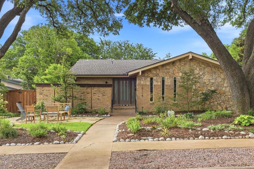 Tucked beneath a canopy of mature trees and thoughtfully redesigned throughout, this beautifully remodeled Mid Century Modern home offers a rare blend of architectural charm, functional living, and incredible outdoor spaces that make the home feel like a private treehouse retreat. The main level features an open-concept living, dining, and kitchen space filled with natural light and serene treetop views. The eat-in kitchen is both stylish and functional with quartz countertops, stainless steel appliances, and seamless flow for everyday living and entertaining. Three bedrooms are located on the main level, while the lower level offers a spacious family room, laundry room, and private fourth bedroom with ensuite bath—ideal for guests, teens, or a quiet work-from-home setup. Additional highlights include Elfa storage systems in five closets and the pantry, a home generator, and a two-car garage with epoxy flooring and ample storage. Completing the property is a guest quarters above the garage featuring a full kitchen and ensuite bath, perfect for visitors, extended stays, income potential, or additional flexible living space. Multiple outdoor living spaces create a peaceful, elevated feel throughout the property. Enjoy mornings surrounded by the trees from the upstairs deck with Trex slats and rails, unwind around the propane fire pit on the front stone patio, or host gatherings on the covered lower patio overlooking the lushly landscaped backyard filled with mature trees and native plants. The fully turfed backyard with sprinkler system and board-on-board privacy fence offers both beauty and low-maintenance living. Ideally located within walking distance to White Rock Lake, Hexter Elementary, and beloved neighborhood restaurants, this exceptional home captures the very best of Old Lake Highlands living.