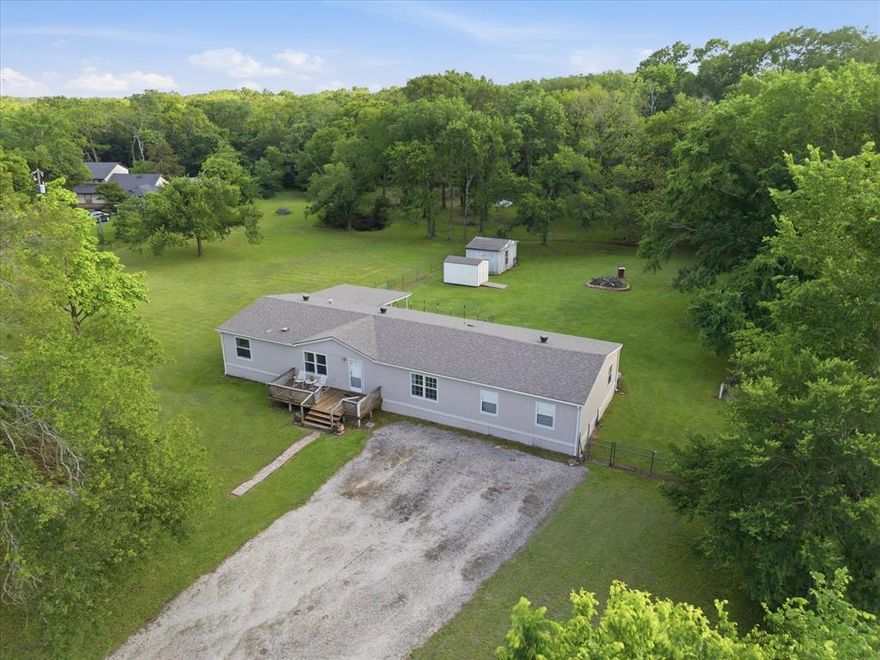 Trade the hustle of city living for a slower, more peaceful lifestyle on this serene 3-acre property, ideally located just 10 minutes from Historic Downtown Kaufman and 30 minutes from First Monday Trade Days in Canton. Bring your animals and unwind with quiet evenings on the inviting front or back deck, surrounded by the perfect combination of beautiful open space and mature trees. Once inside, you’ll find a neutral freshly painted interior and hard surface flooring throughout, no carpet. The inviting living room is highlighted by a vaulted ceiling and open sight-lines into the kitchen and dining area. The eat-in kitchen offers a functional layout with a movable island, perfect for everyday living. The primary bedroom is split from the secondary rooms providing ample privacy, and features an ensuite bath with dual sinks, a large relaxing garden tub, a beautifully refreshed shower, and updated tile flooring. You'll also find a versatile flex room located off the primary bedroom that can easily serve as a home office or den. Two additional bedrooms share access to a well appointed full bath with a linen closet. Outdoors, the property is well-equipped for country living with a 400 sq. ft. workshop that can double as storage or be converted into additional living space, a 12x8 equipment shed, and a chicken or pig coop. The front open pasture and fenced back pasture provide ample space for grazing, making this an ideal setup for those looking to embrace the simplicity and charm of rural life.
