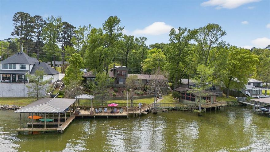 Discover architectural charm & natural beauty with this exquisite 3bedroom, 3.5bath lakehouse, set against the serene backdrop of Cross Lake. The cottage was rebuilt the 950sqft from the slab up with an additional full bedroom, bath & screened in outdoor living & kitchen space to be enjoyed year round! Featuring a blend of rustic influences & modern amenities, this home offers a unique sanctuary just moments from the vibrant heart of Shreveport. Step into a living space full of light from large, expansive windows that frame uninterrupted views of the lake. The stunning French chateau style gates & railings add an element of sophistication to the property. At its heart lies a huge gourmet kitchen, a dream for any culinary enthusiast, complete with premium appliances including a SubZero refrigerator, Thermo double builtin ovens & ice maker. The full home generator with surge suppressor is a must. The interior is thoughtfully designed to accommodate both intimate family living & entertaining. The oversized primary suite stands as a testament to comfort with luxury, featuring an abundance of closets with additional storage options, making organization effortless. Outside, the property truly shines with its architecturally unique design that wraps you in panoramic water views at every turn. A spacious deck offers an elevated vantage point over 140 feet of pristine lakefront, perfect for tranquil evenings or lively gatherings. The lakefront location promises not only views but also access to a range of water activities to enjoy year round. This Shreveport home masterfully combines elegance, function & idyllic natural surroundings, offering a rare opportunity for refined lakeside living. Whether it’s the view, extra parking, 3 docks or the stylish finishes, every detail of this property has been curated to provide an unparalleled living experience on Cross Lake.
