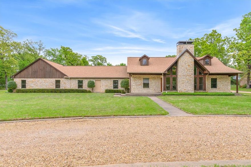 Stunning Custom Stone and Cedar Home is nestled on 2.37 manicured and treed acres in beautiful Lakewood Trails offering a cul-de-sac street replete with mature trees and homes set back from the road, just a few miles from Hwys 19 and 243. A circle drive leads to this one-story 2408 sq. ft., 4 bed 3 bath ONE OWNER home. Enter a dramatic Great Room reminiscent of mountain homes with its vaulted wood ceiling and stone WBFP flanked by peaked windows. Open floor plan means your Dining, Breakfast Bar and Kitchen are open to the Great Room. Split bedrooms with the Primary large enough for a sitting area with ensuite bath. Other bedrooms offer large double closets and a full bath in the hall. Attached 3 car garage is perfect for all your vehicles or toys. On the far side of the garage enter the Guest Apartment with a huge open Living-Bedroom area, Kitchen and full Bath, perfect for family or even rental with its own entrance and zoned HVAC. Both the Main Home and the Guest Apartment exit to covered porches for relaxation with views of lush lawns and trees. Ample drives access the back-entry garage as well as the Workshop and Greenhouse Structure. The Workshop is 35 x 20 and offers 2 rooms. One is insulated with a heating and cooling system (large enough to also service the 2nd room if desired). 2nd side is perfect for storage and lawn equipment. Roof replaced in 2024 and newer AC units replaced in 2023 (main home) and 2018 (Guest). Many updates (see list provided). Automatic water sprinklers, both City Water and Private Well. Room for gardens and pets. This home was well designed, built and maintained. It is hard to find established neighborhoods with the ambience and natural beauty found here. Your own slice of country with the easy access to Canton schools, shopping and commute to Dallas or Tyler. Note: Total beds and bath include the Guest Apartment.