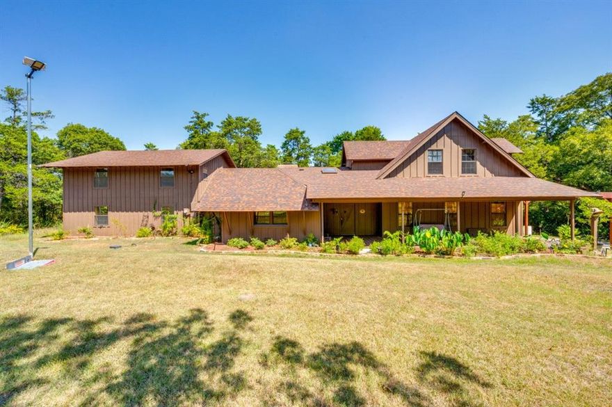 ONE-OF-A-KIND!!! Discover your own private Cedar Hill retreat on over 12.07 acres of tranquil wilderness surrounded by nature. This UNIQUE HOME of 4-bedroom, 6-bath, 4,000sqft blends rustic cabin charm with modern comforts. At the heart of the home, a cozy log-style living area with soaring wood-beamed ceilings and a see-through fireplace connects two spacious living rooms, creating a welcoming space for gatherings or quiet evenings.  The bright, open eat-in kitchen features built-in appliances, ample cabinetry, and plenty of space for family meals or entertaining. Each bedroom includes a private unsuited, including a serene primary suite with a custom closet and spa-like bath. A large loft overlooks the main living area, perfect for a home office, reading nook, or media space.  Step through French doors to a covered porch overlooking your own wooded oasis, where towering trees, wildlife, and the sounds of nature create a peaceful, national-park-like setting. Rich wood floors and ceilings throughout, complemented by tile in bathrooms and utility areas, add warmth and elegance, while vaulted ceilings and exposed beams give the home a spacious yet cozy feel.  This exceptional property offers the rare combination of privacy, natural beauty, and rustic elegance—all just minutes from town. Whether entertaining inside or enjoying the tranquility of the outdoors, this home provides a true nature-inspired retreat in the heart of Texas.  3D video is available.  Call now!