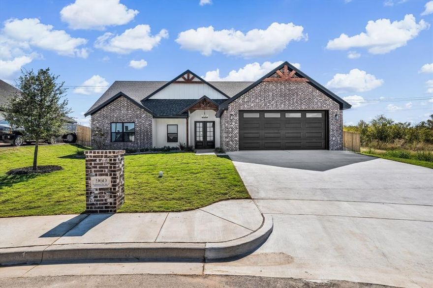 This new custom home sits at the end of a cul-de-sac in the established Moonlight Park community, surrounded by other beautiful custom homes. Thoughtfully designed, it blends modern Tuscany style with open, comfortable living. Inside, you’ll find wood-beamed ceilings, a brick wood burning fireplace with custom built-ins, and large windows that bring in plenty of natural light. The kitchen is truly the heart of the home featuring quartz countertops, a custom island with seating, built-in cooktop, oven, microwave, and dishwasher all tied together with rich textures and warm wood accents. The primary suite is tucked away for privacy and includes a soaking tub, walk-in shower, double vanity, and a spacious walk-in closet. Two additional bedrooms offer generous space, and the half bath off the living area is perfect for guests. Step outside to enjoy a covered patio overlooking a fenced backyard, ideal for relaxing or entertaining. The oversized two-car garage was built to fit large SUVs or trucks comfortably. From the elegant design to the quality finishes, every detail in this home was crafted with care it’s the perfect mix of timeless character and modern comfort.