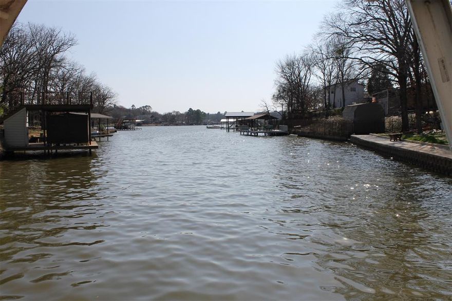 Neat and clean waterfront home with nice spread out living space, Offers 2 living areas, 3 bedrooms and 2 and one half baths. Large carport across street side of lot, multiple storage buildings. Inside has vinyl wood plank flooring, fresh paint, newish appliances. Back of home was added with large living space,dining area, and flex space for office, work out area or extra sleeping space. Beautiful lake view of channel to open water. DEEP WATER channel!! Boat house has party deck with beautitul views, electric lift, one PWC lift. Lovely landscaping, fully fenced for your kids and pets, tons of storage inside and outside. Great lakehouse and a great value as well. Come see it today. Original home was site built modular home with custom built add-on. All info to be verified by buyer or buyers agent. Info deemed reliable but not guaranteed.